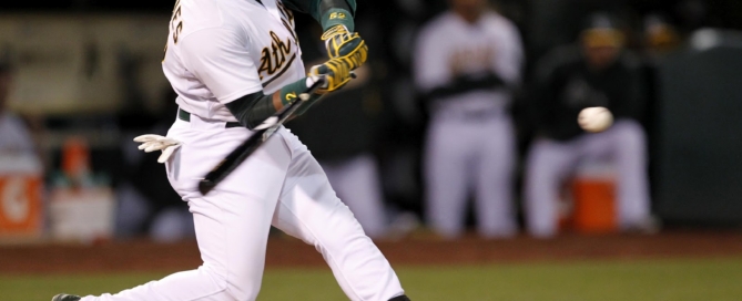 Baseball player swinging bat at incoming pitch